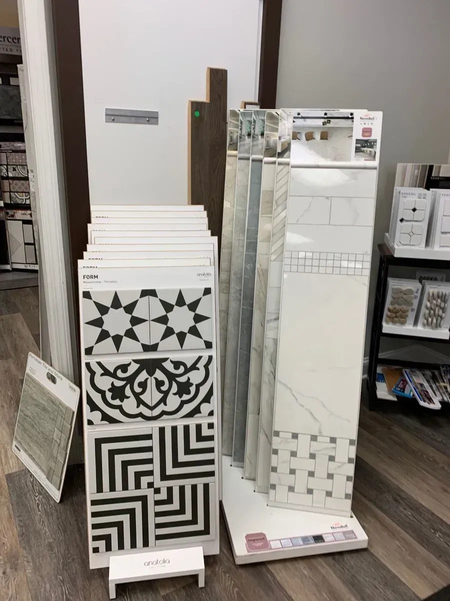 A display of tiles is sitting on a wooden floor in a store.