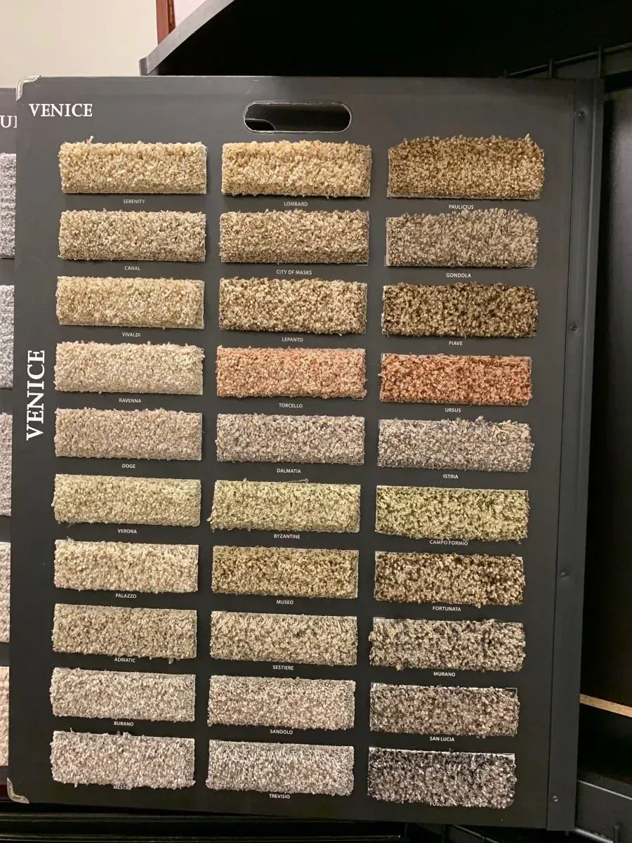 A display of venice carpet samples on a shelf