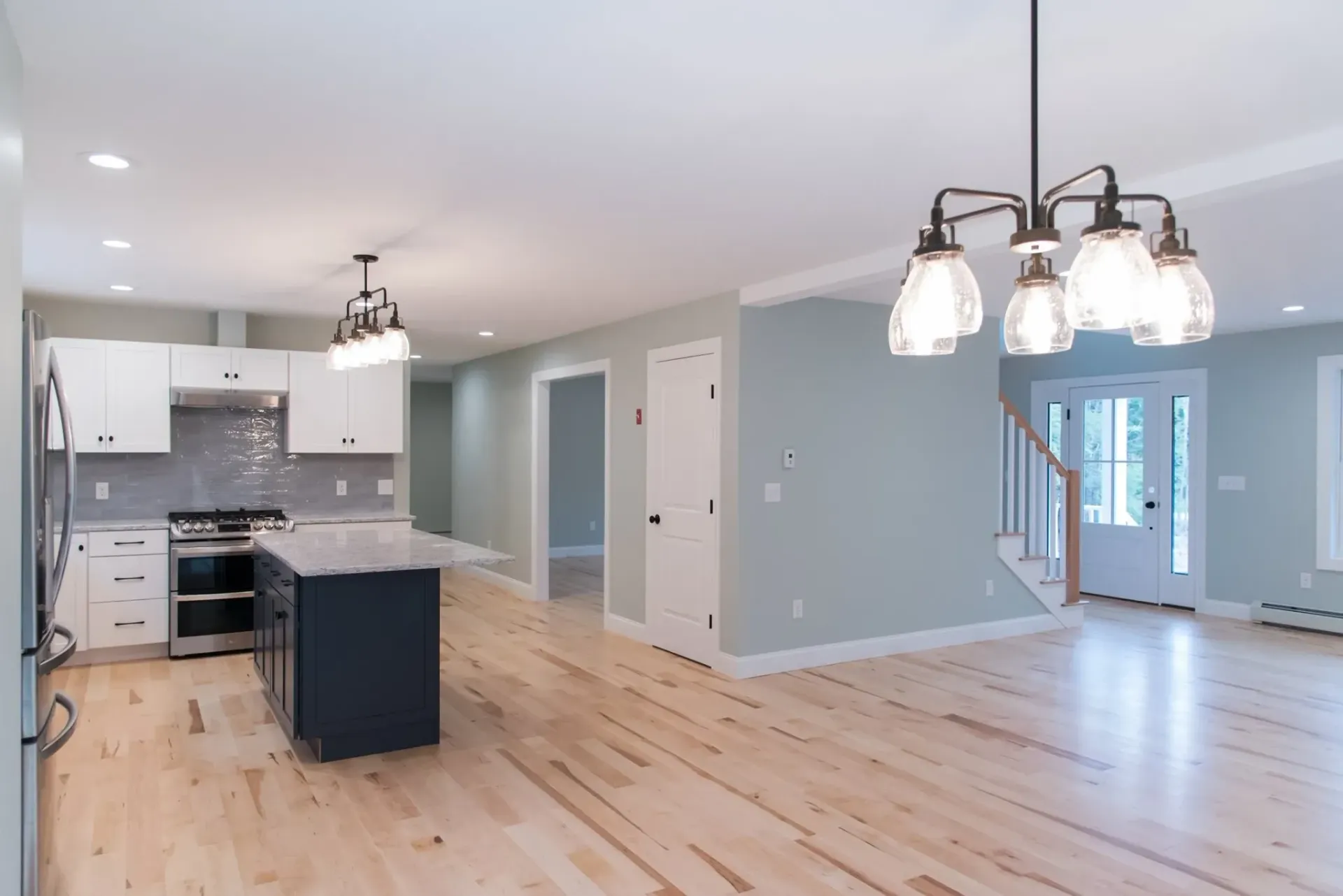 A kitchen with a large island and a chandelier hanging from the ceiling