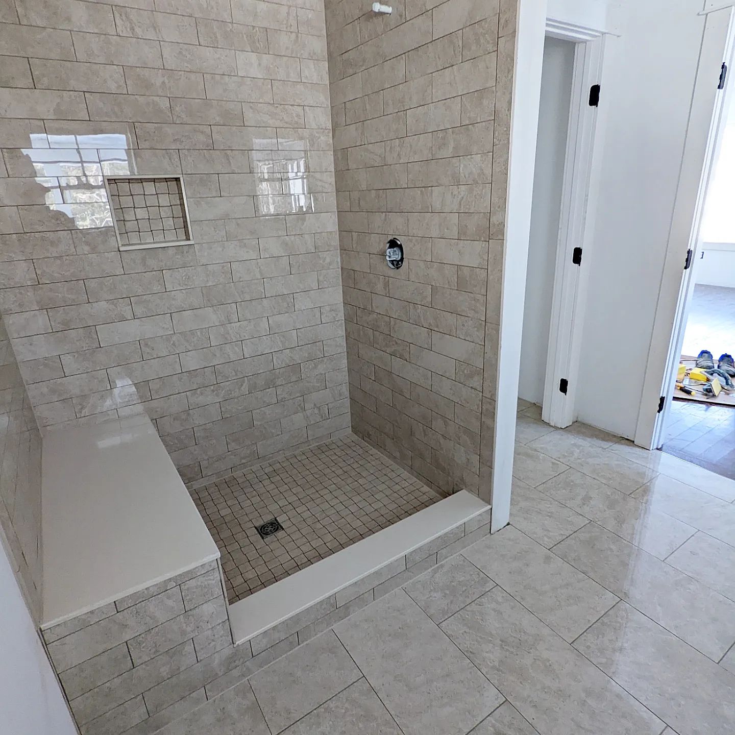 A bathroom with a walk in shower and a bench