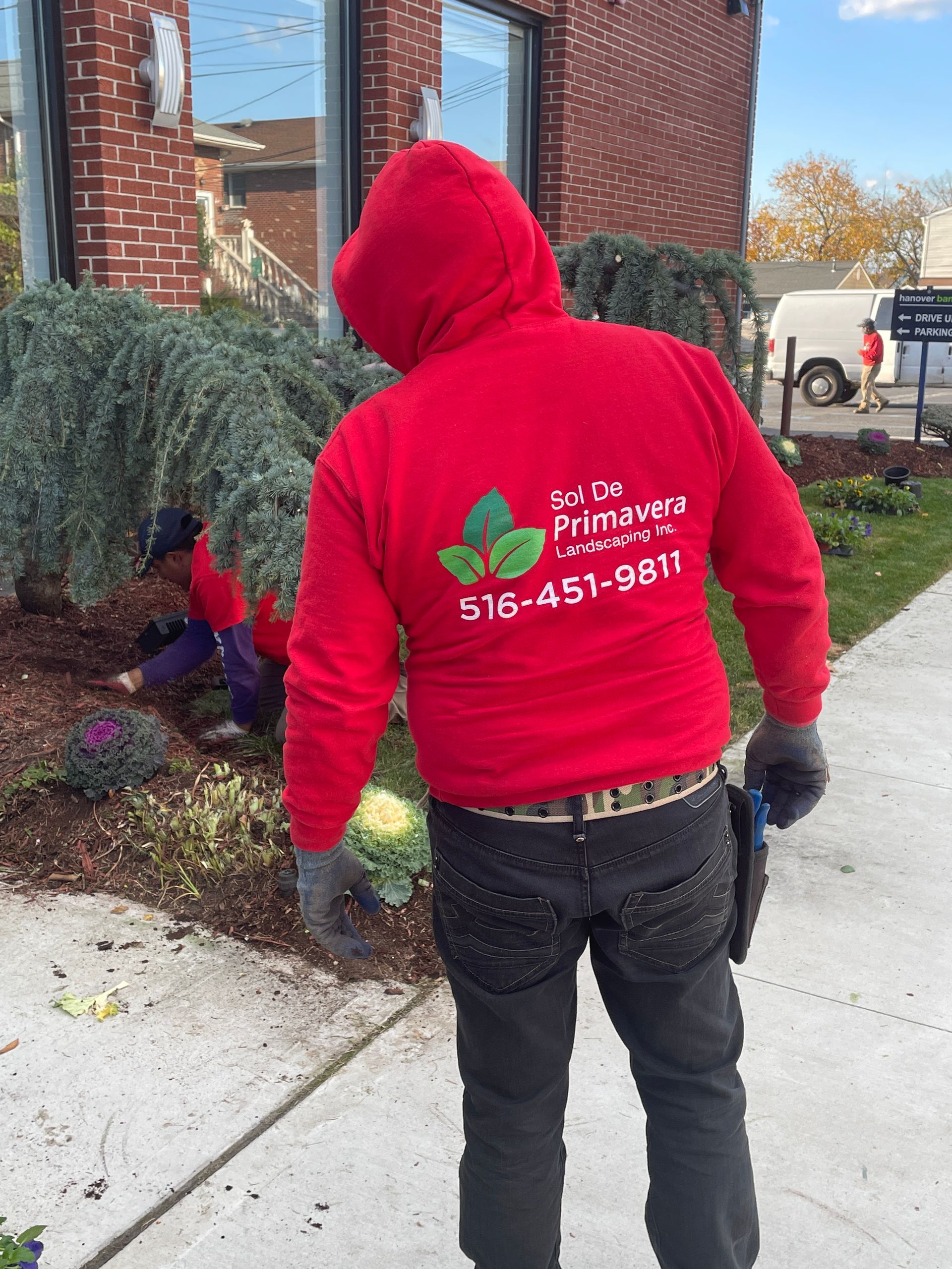 A man wearing a red hoodie with a phone number on the back