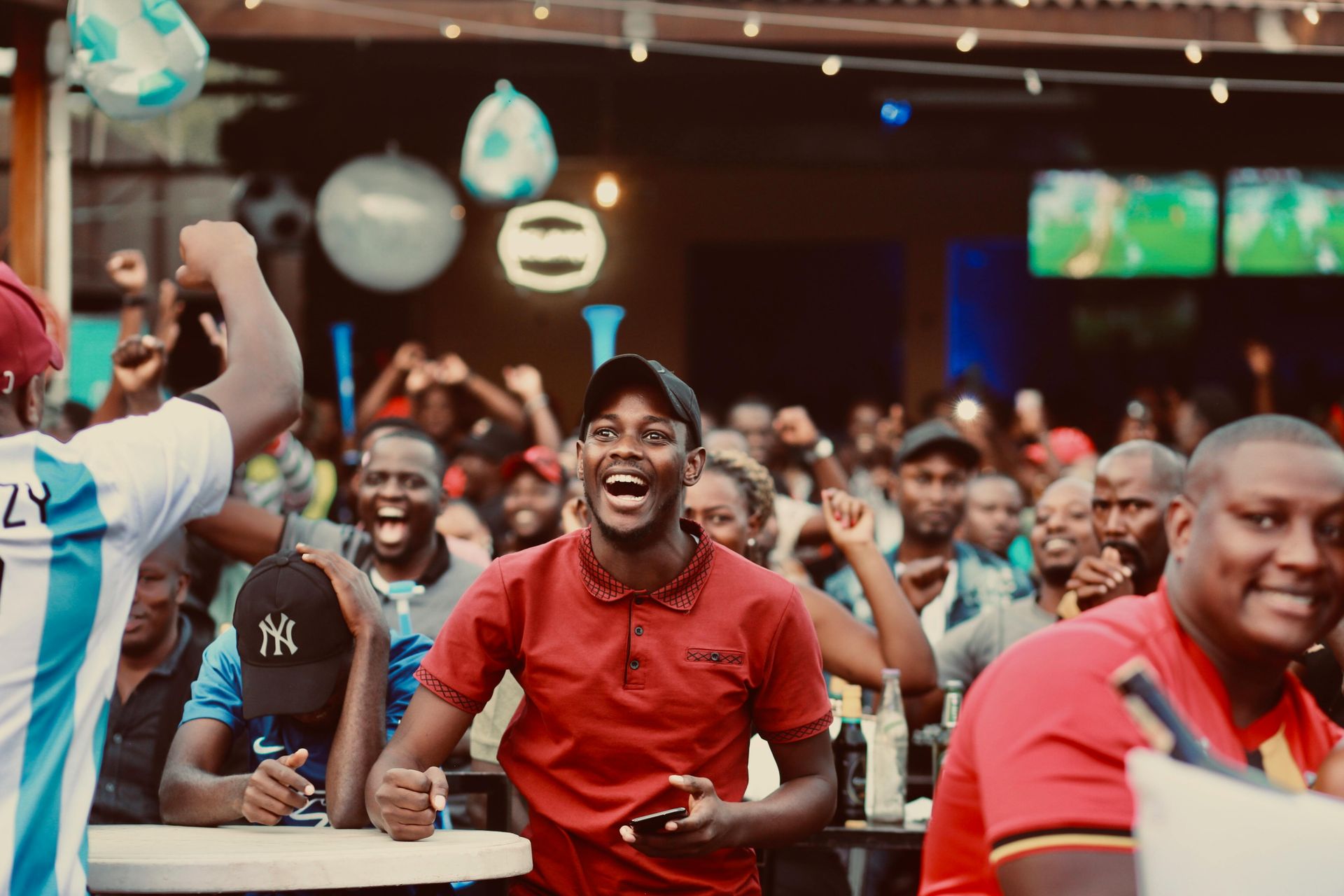 A group of people are watching a soccer game in a bar.