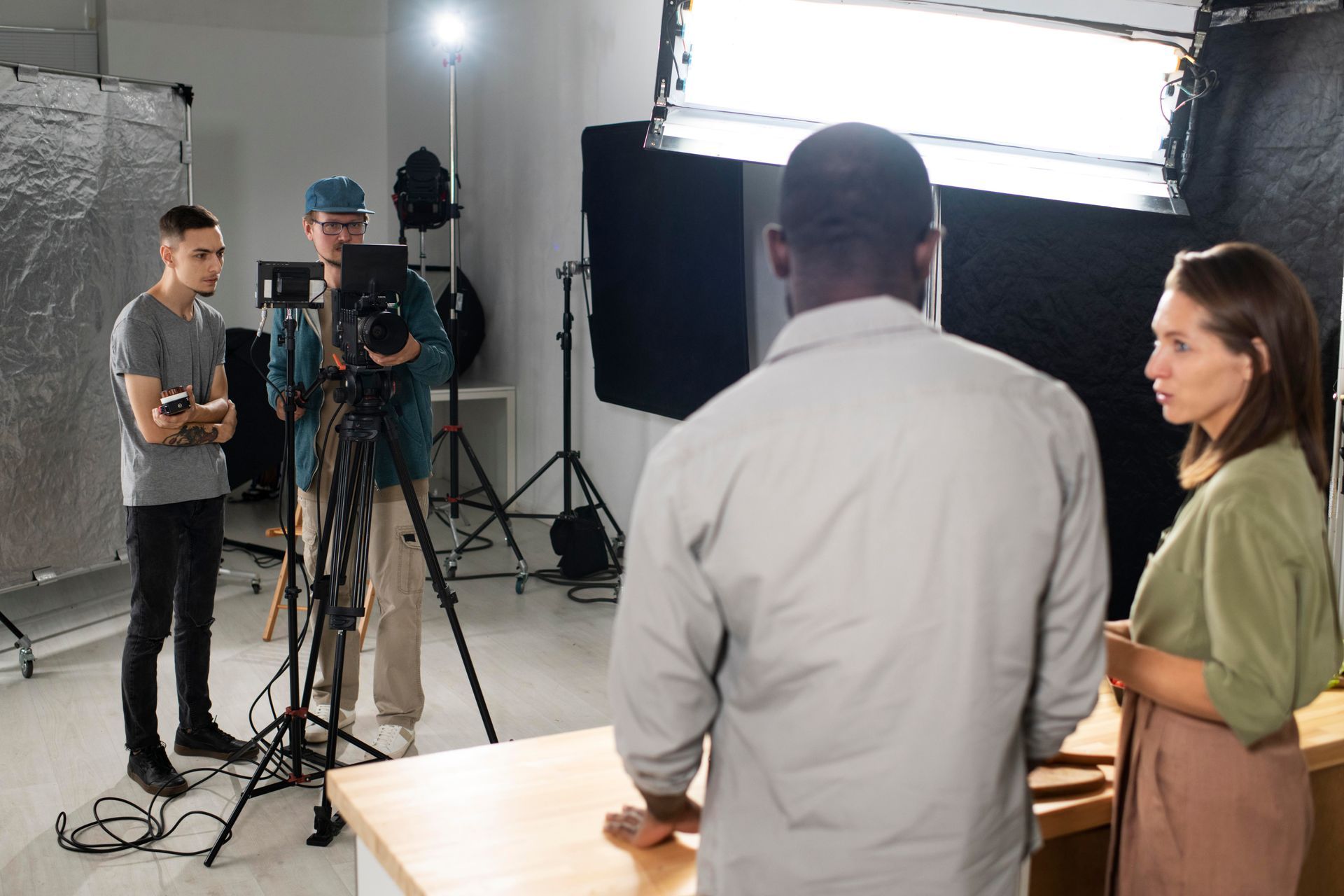 A group of people are standing in front of a camera in a studio.