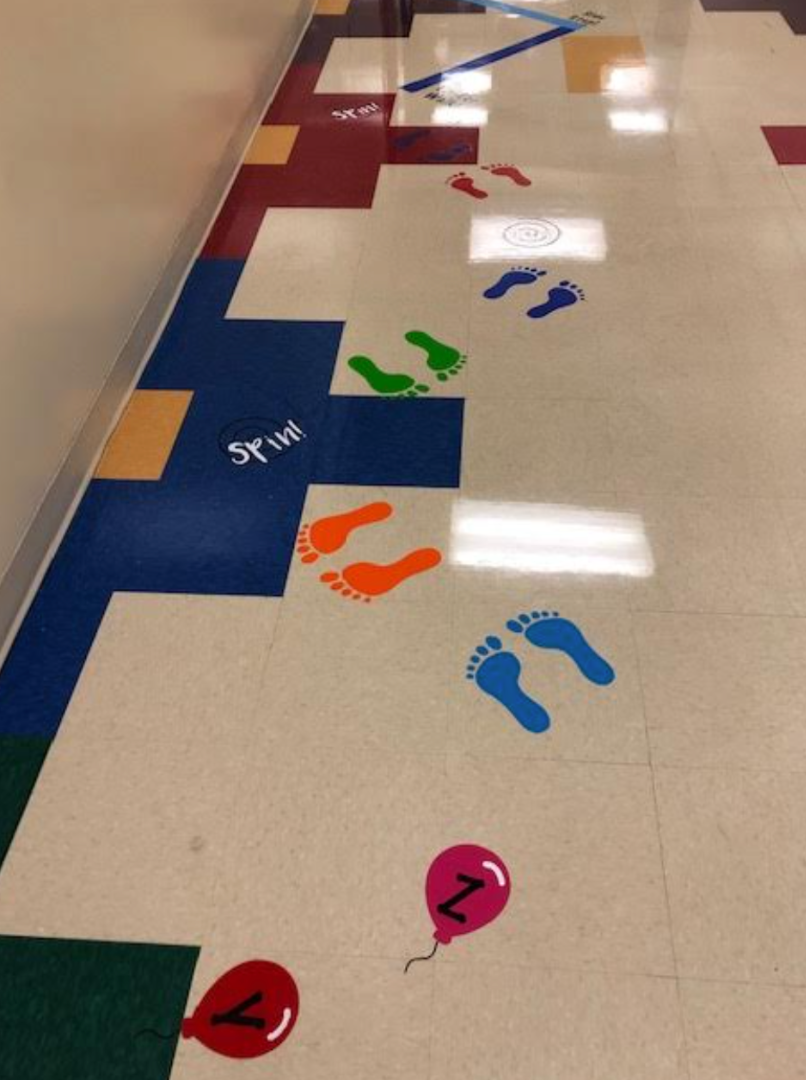 A hallway with footprints and balloons painted on the floor