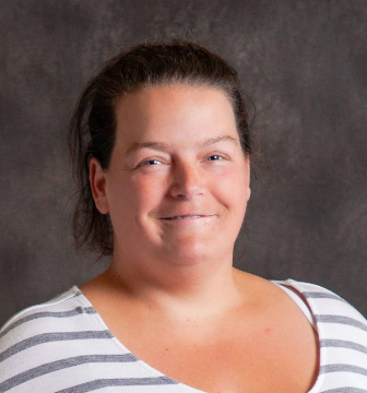 A woman wearing a striped shirt is smiling for the camera.