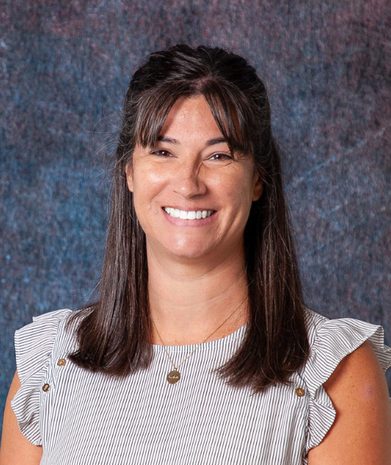 A woman in a floral shirt is smiling for the camera