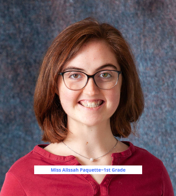 A young woman wearing a blue sweater and a brown shirt smiles for the camera