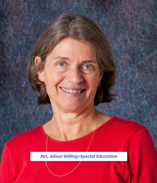 A woman wearing a blue shirt and a black vest smiles for the camera