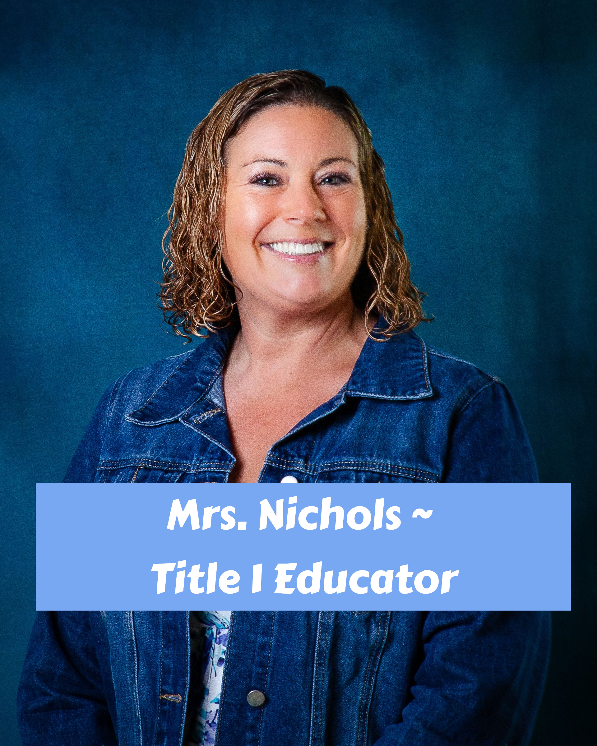A woman with curly hair is smiling and wearing a brown sweater.