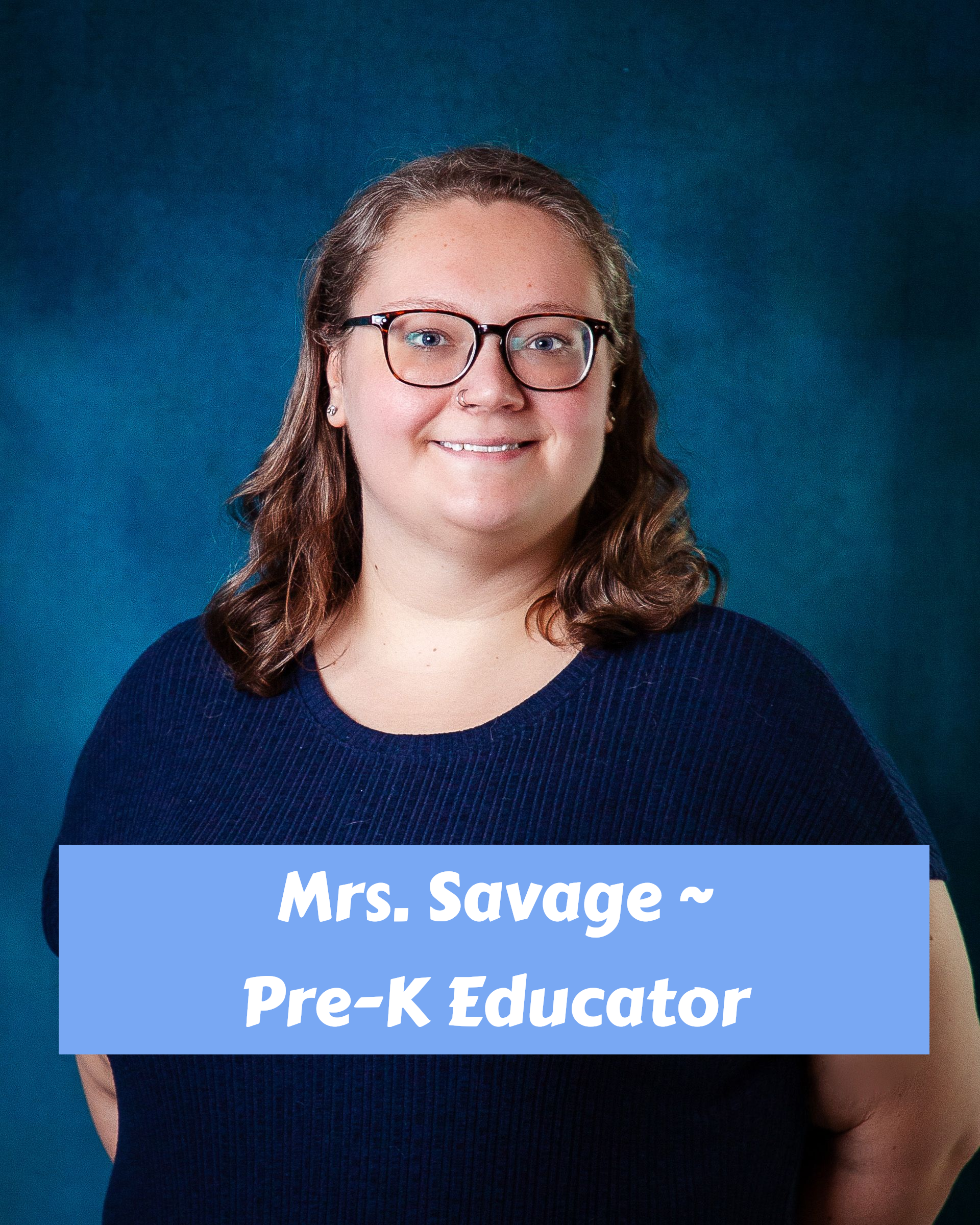 A woman with long brown hair and blue eyes is smiling for the camera.
