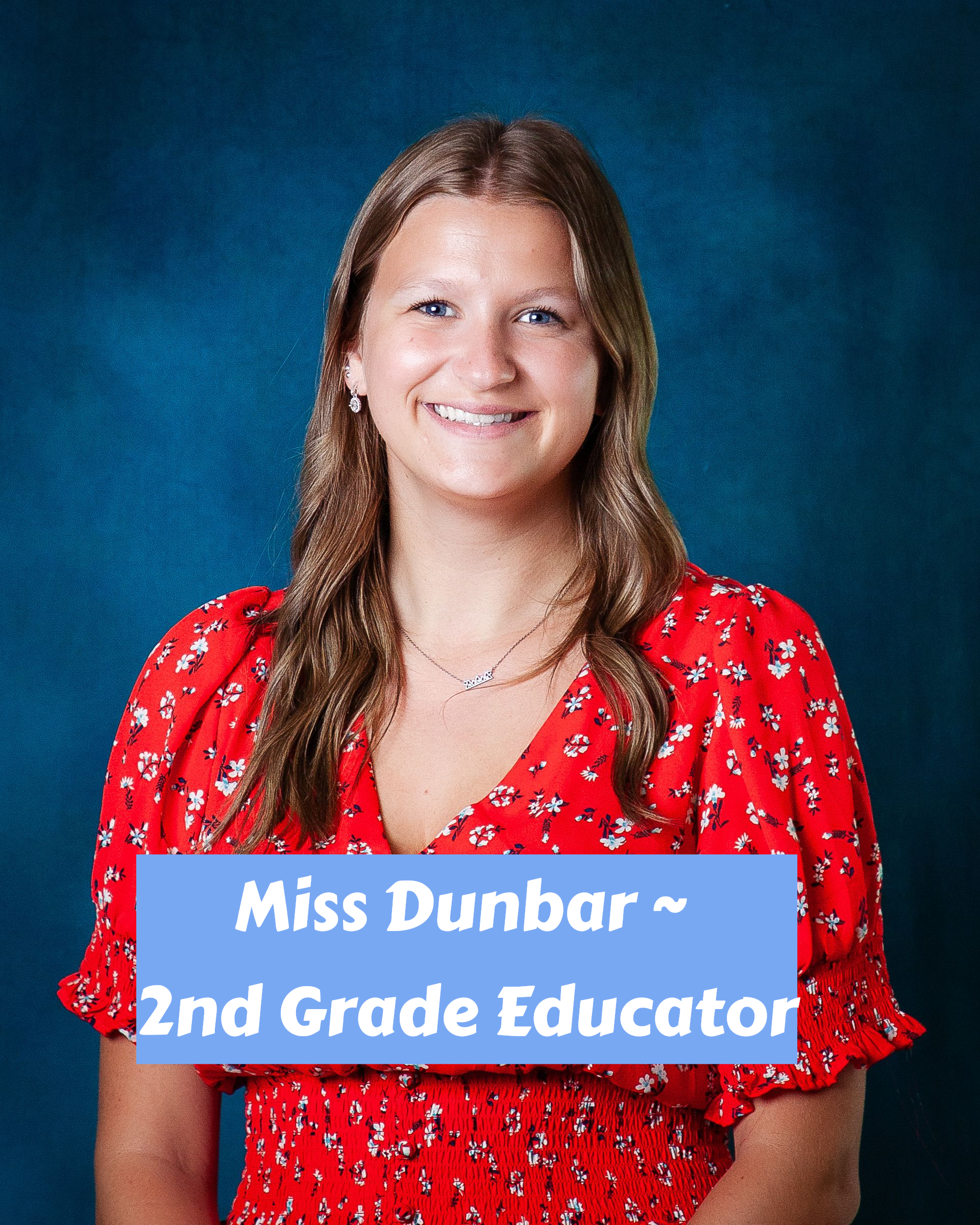 A woman in a white polka dot shirt is smiling for the camera
