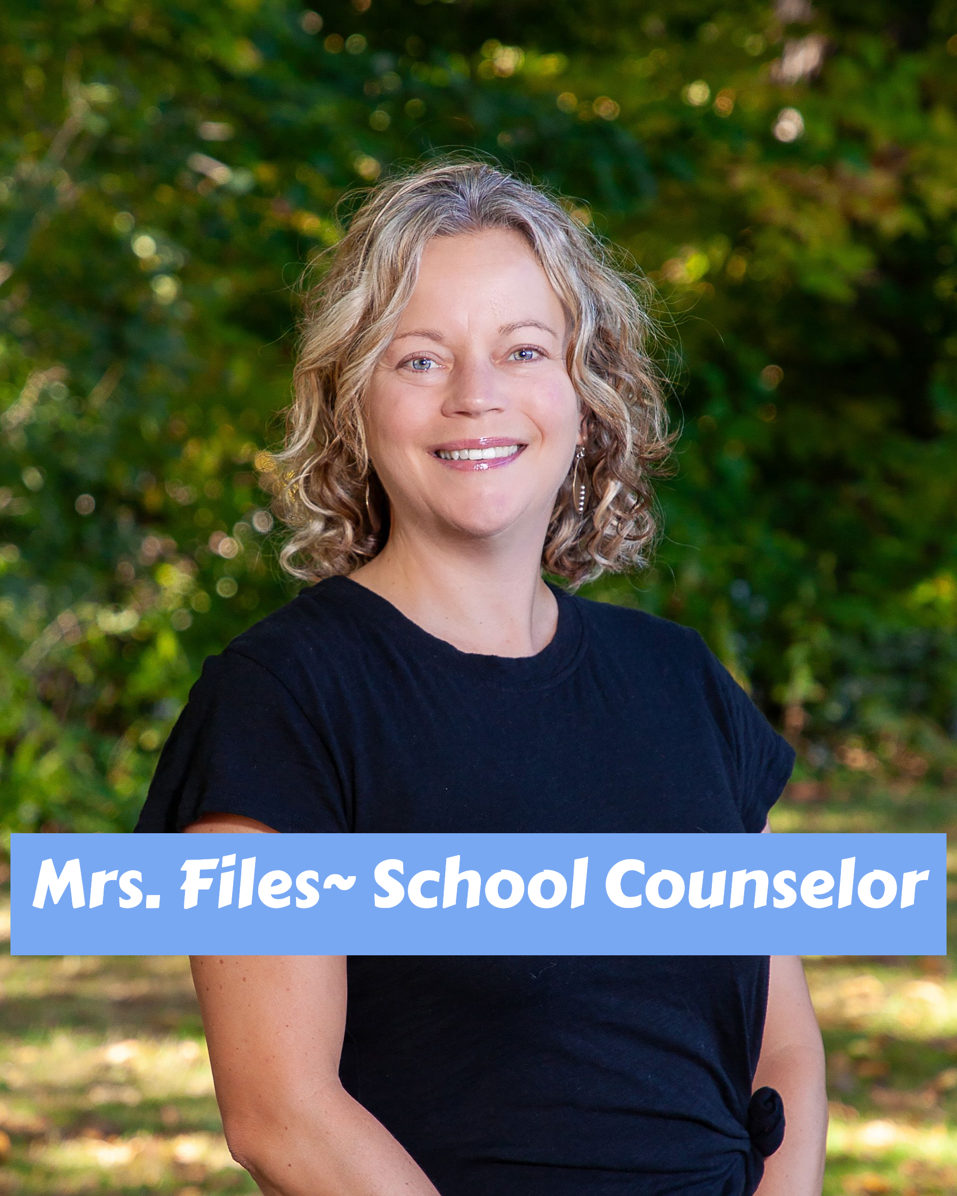 A woman in a blue shirt is smiling for the camera