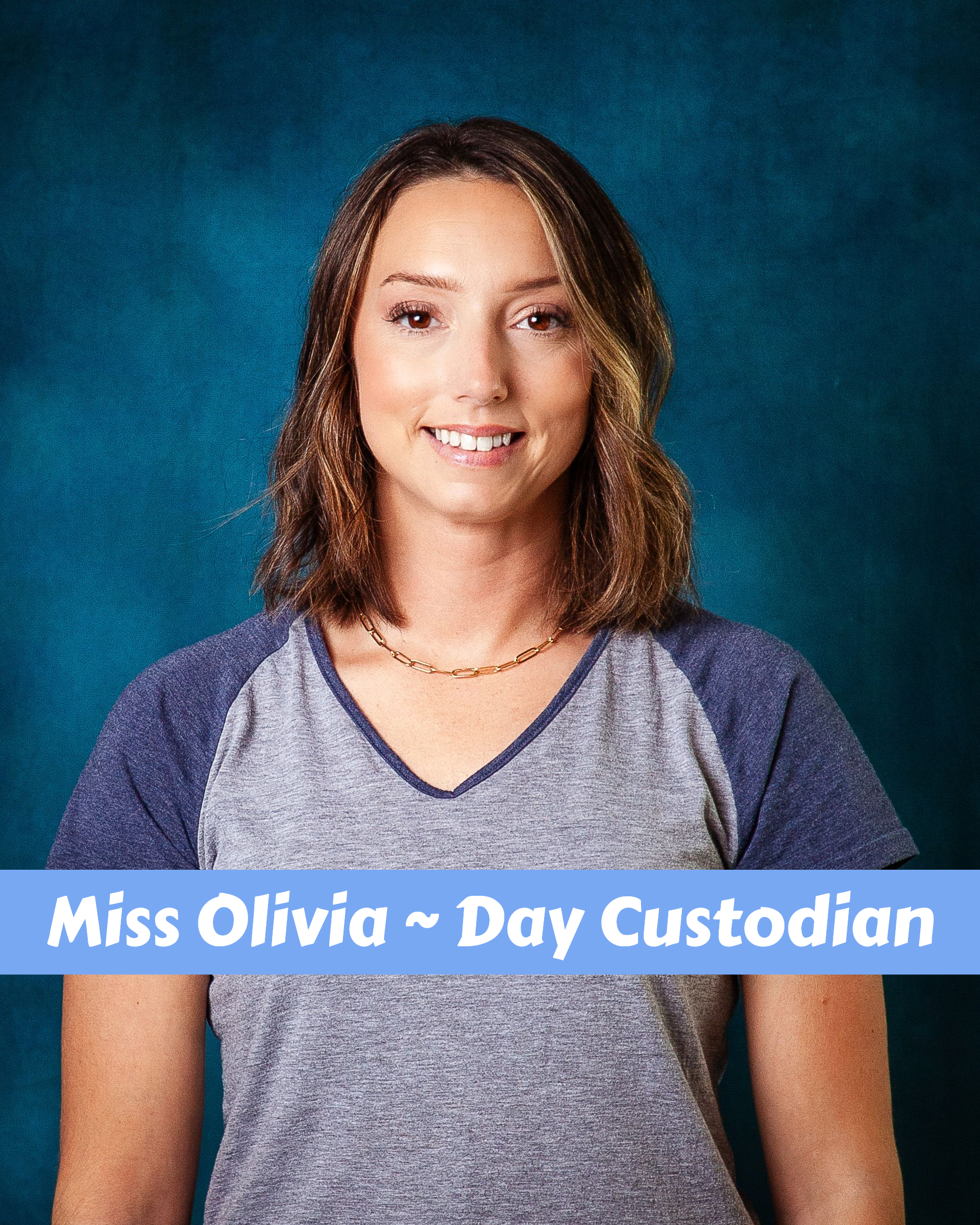 A woman with long hair and a necklace is smiling for the camera.