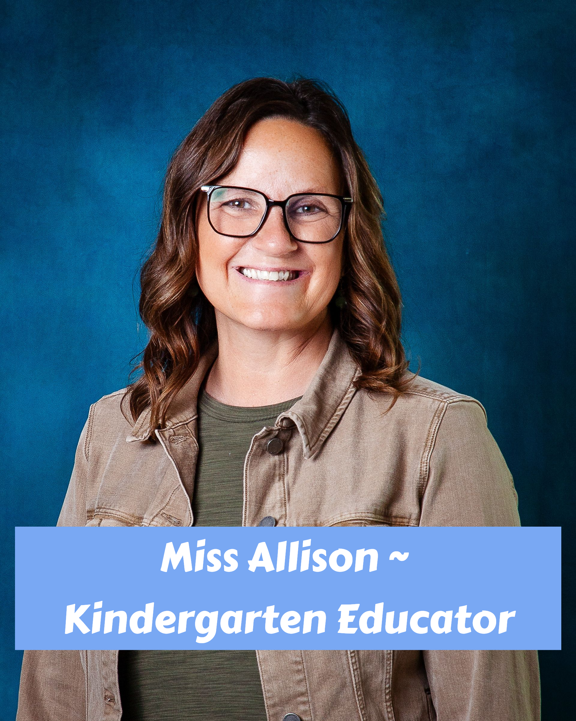 A woman wearing glasses and a red shirt is smiling for the camera.