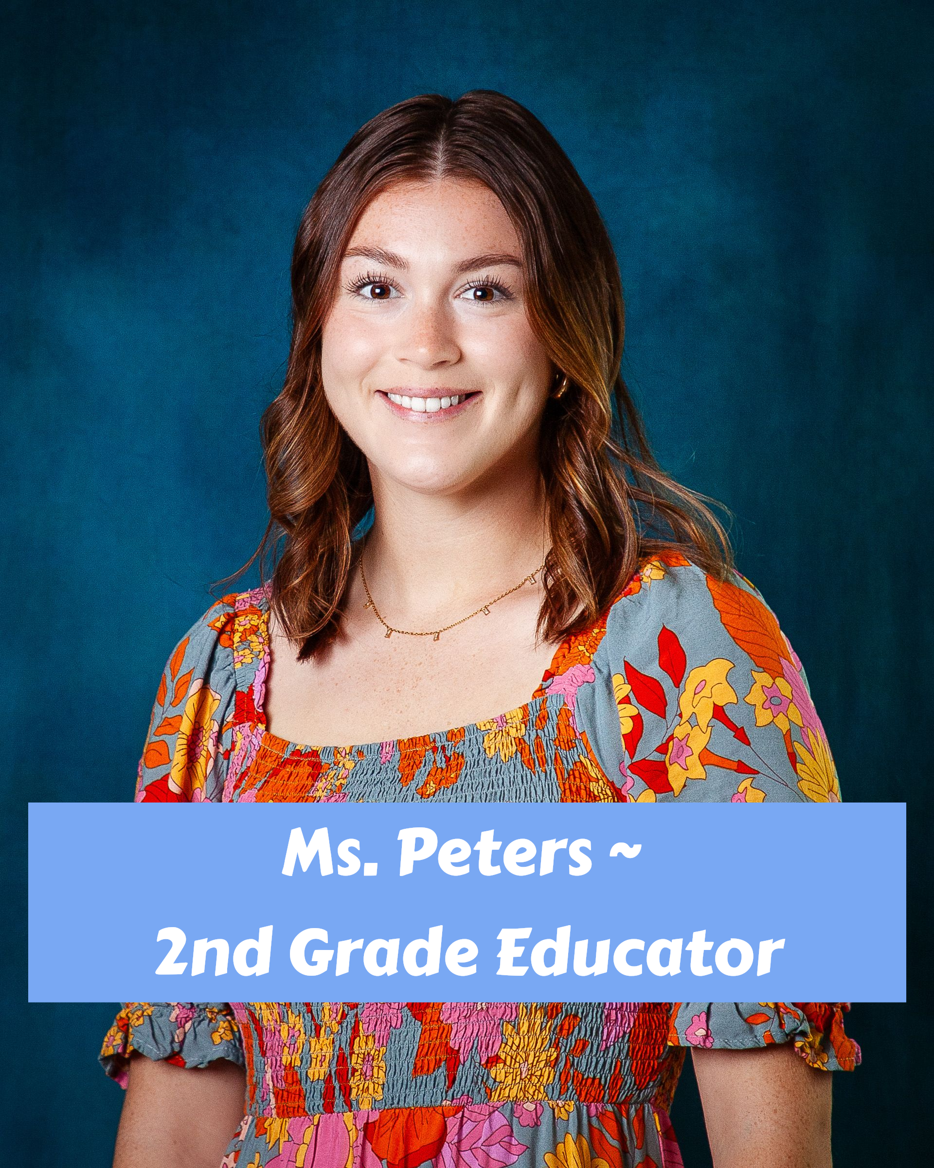 A woman in a pink shirt is smiling for the camera