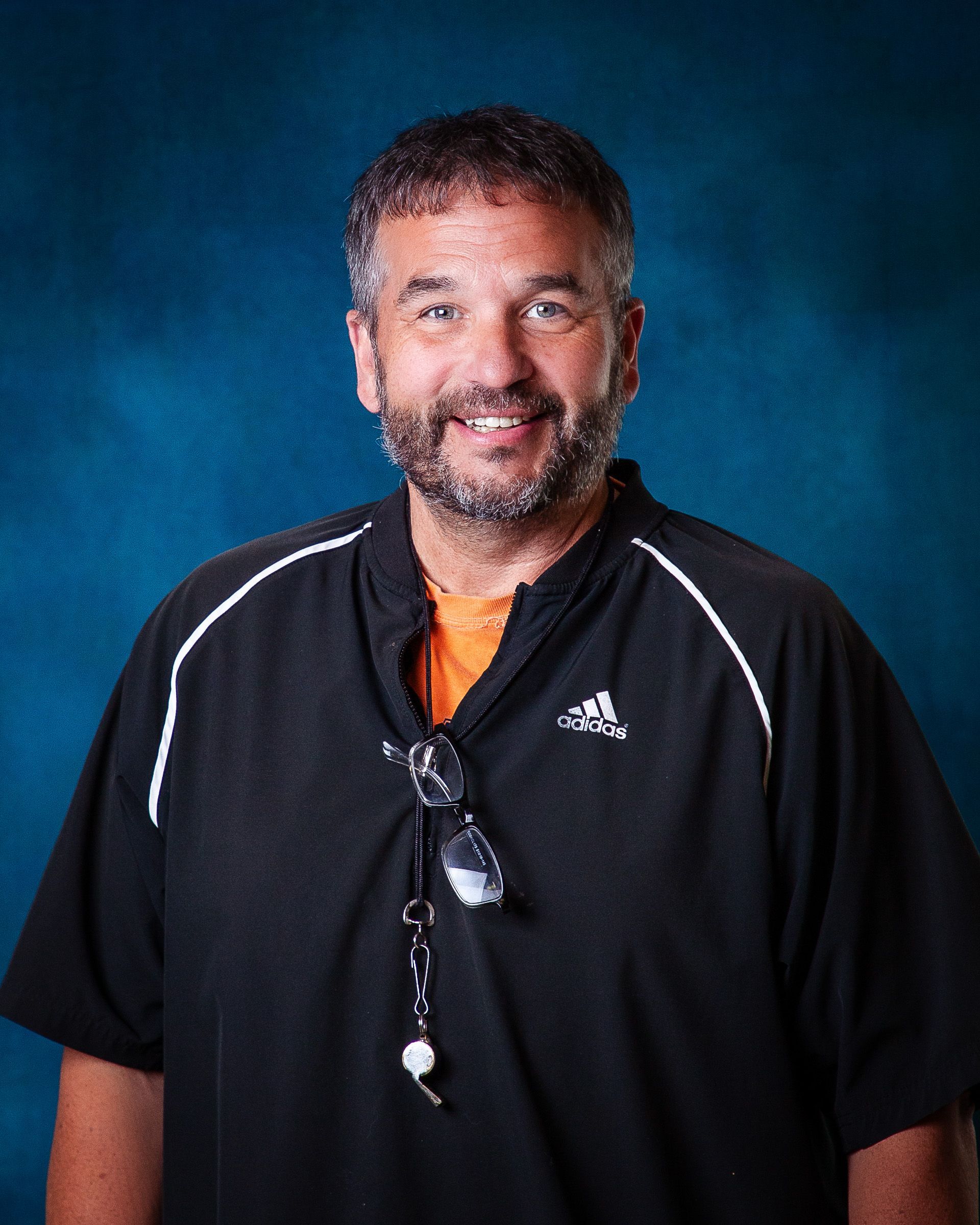 A man with a beard is wearing a grey hoodie