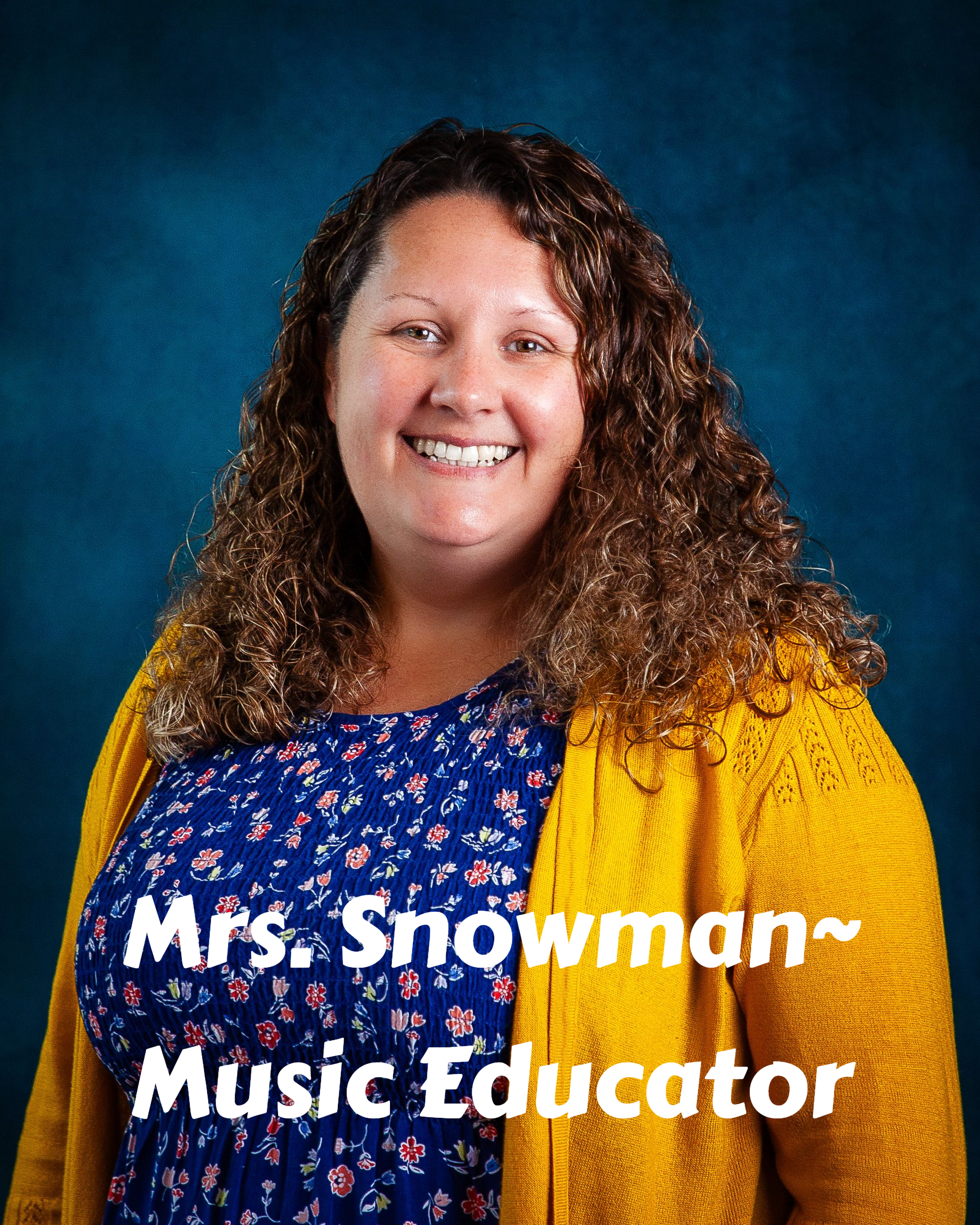 A woman with curly hair is smiling for the camera.