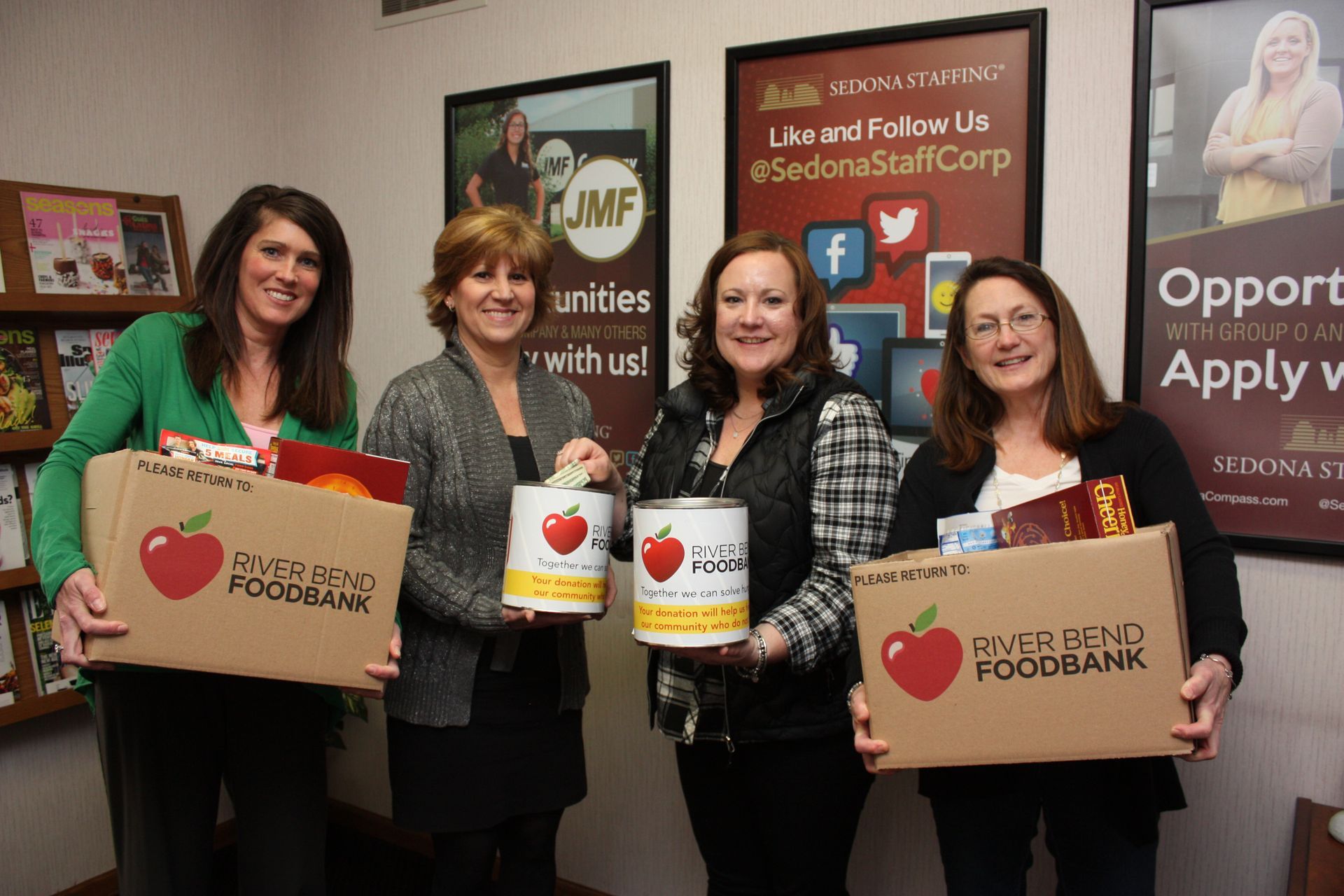 Sedona team holding boxes of food to donate to the Riverbend Foodbank.