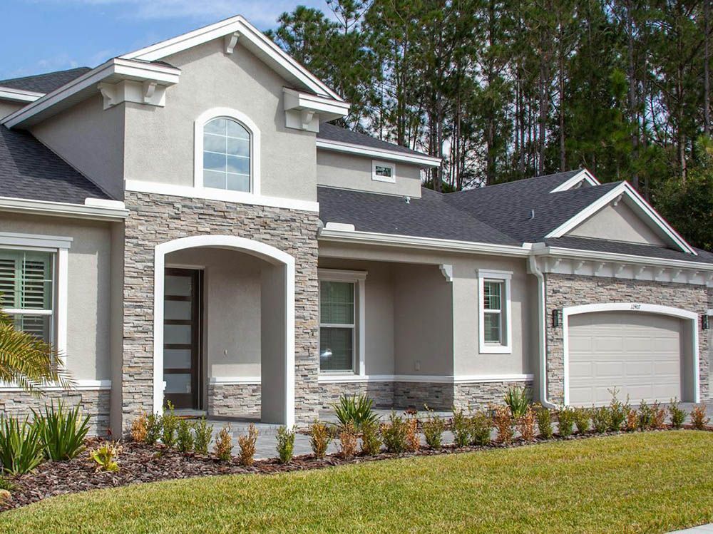 A large house with a stone facade and a garage