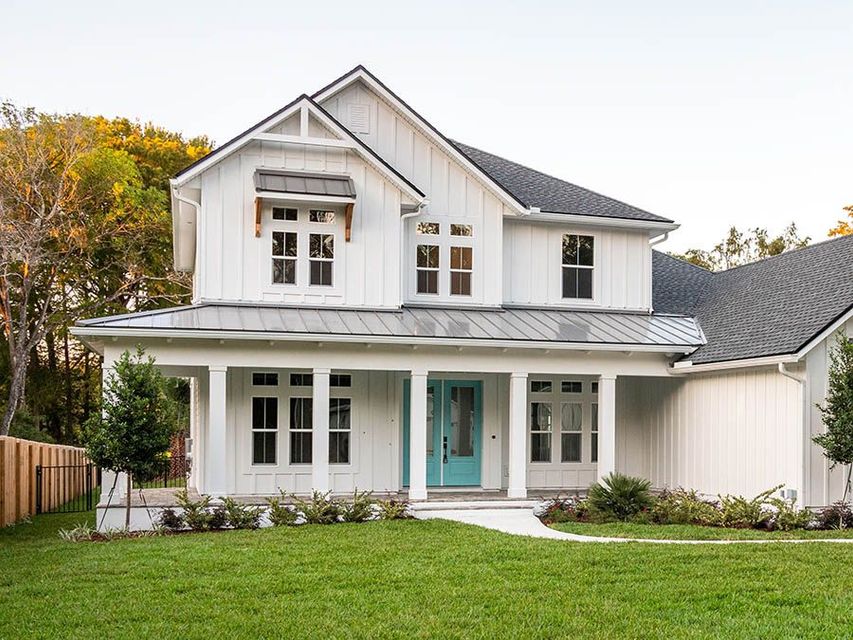 A large white house with a blue front door and porch.