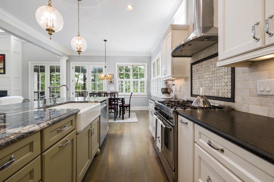 A kitchen with stainless steel appliances , granite counter tops , and white cabinets.