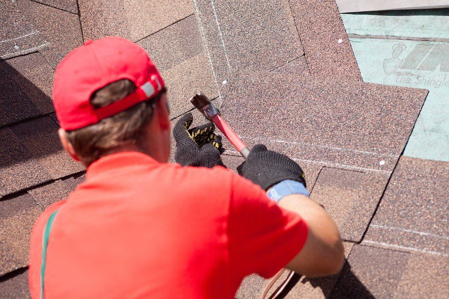 man installing shingle roofing