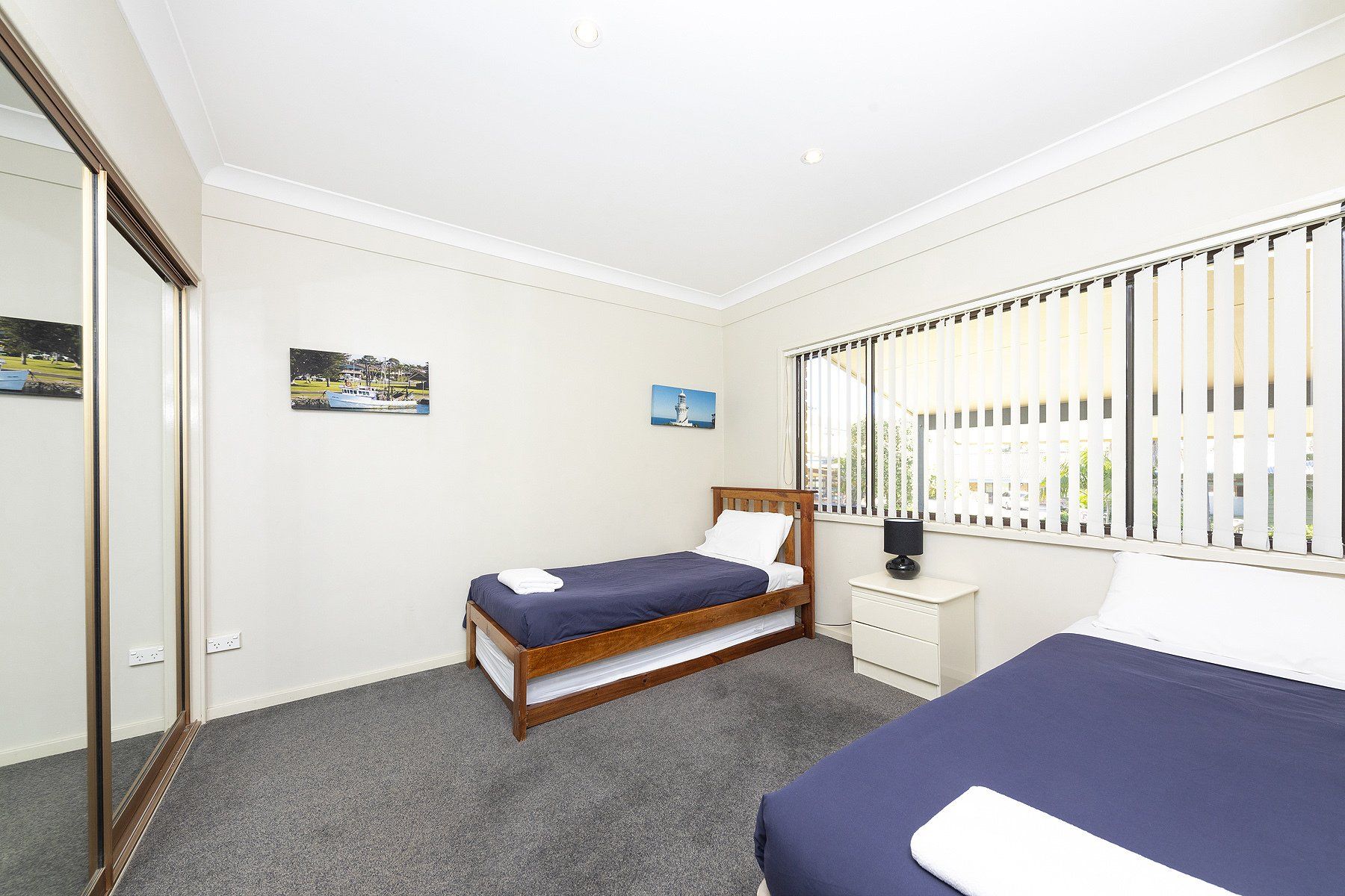 single bed with blue mattress and window