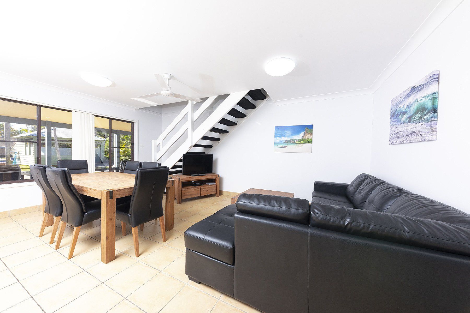 2 bedroom apartment living room with tv and table near stairs