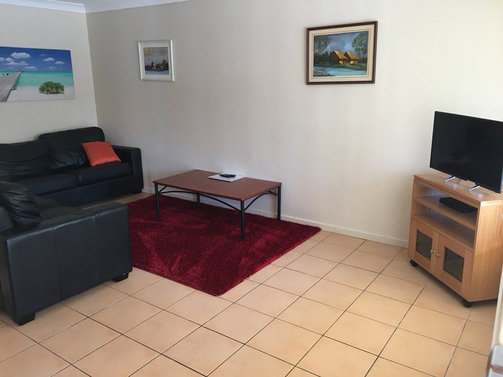 3 bedroom with table and red rug