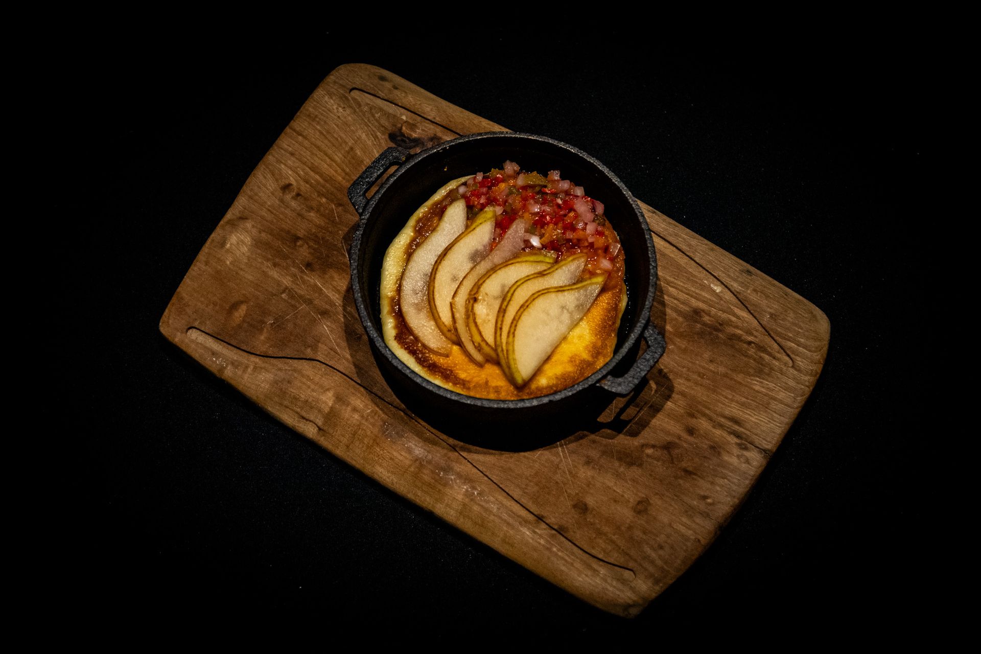 En un plato hay un cuenco de helado con salsa de caramelo encima.
