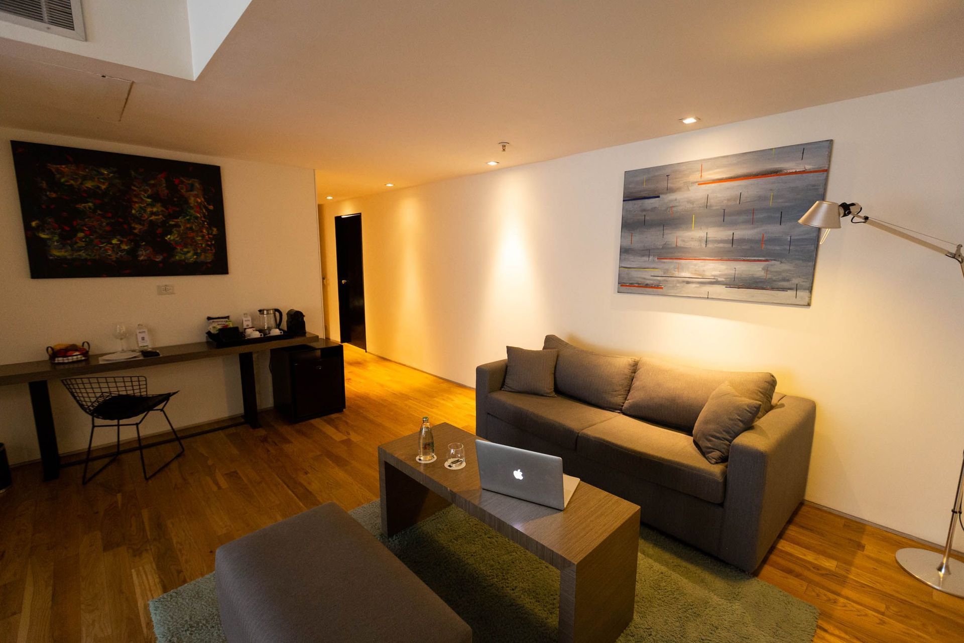 Una sala de estar con un sofá y un ordenador portátil sobre una mesa.