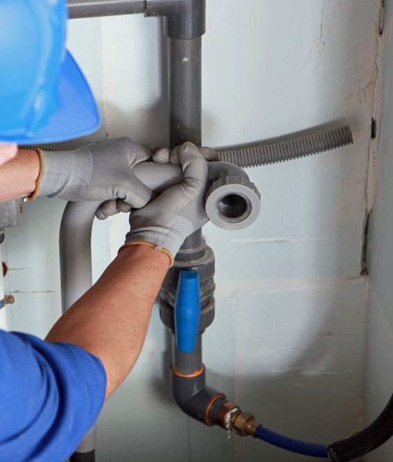 A Man Wearing a Hard Hat and Gloves is Working on a Pipe — J & N Plumbing Pty Ltd In Manilla, NSW