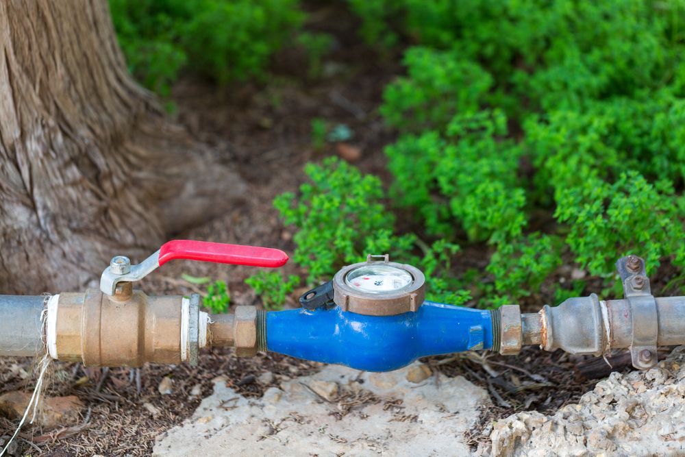 A Water Meter With a Red Handle is Connected to a Pipe — J & N Plumbing Pty Ltd In Tamworth, NSW