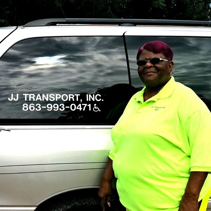 woman professional standing next to J J Transport of Arcadia Inc car