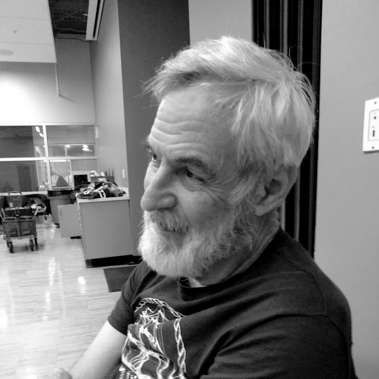A man with a beard is wearing a black shirt with a skull on it