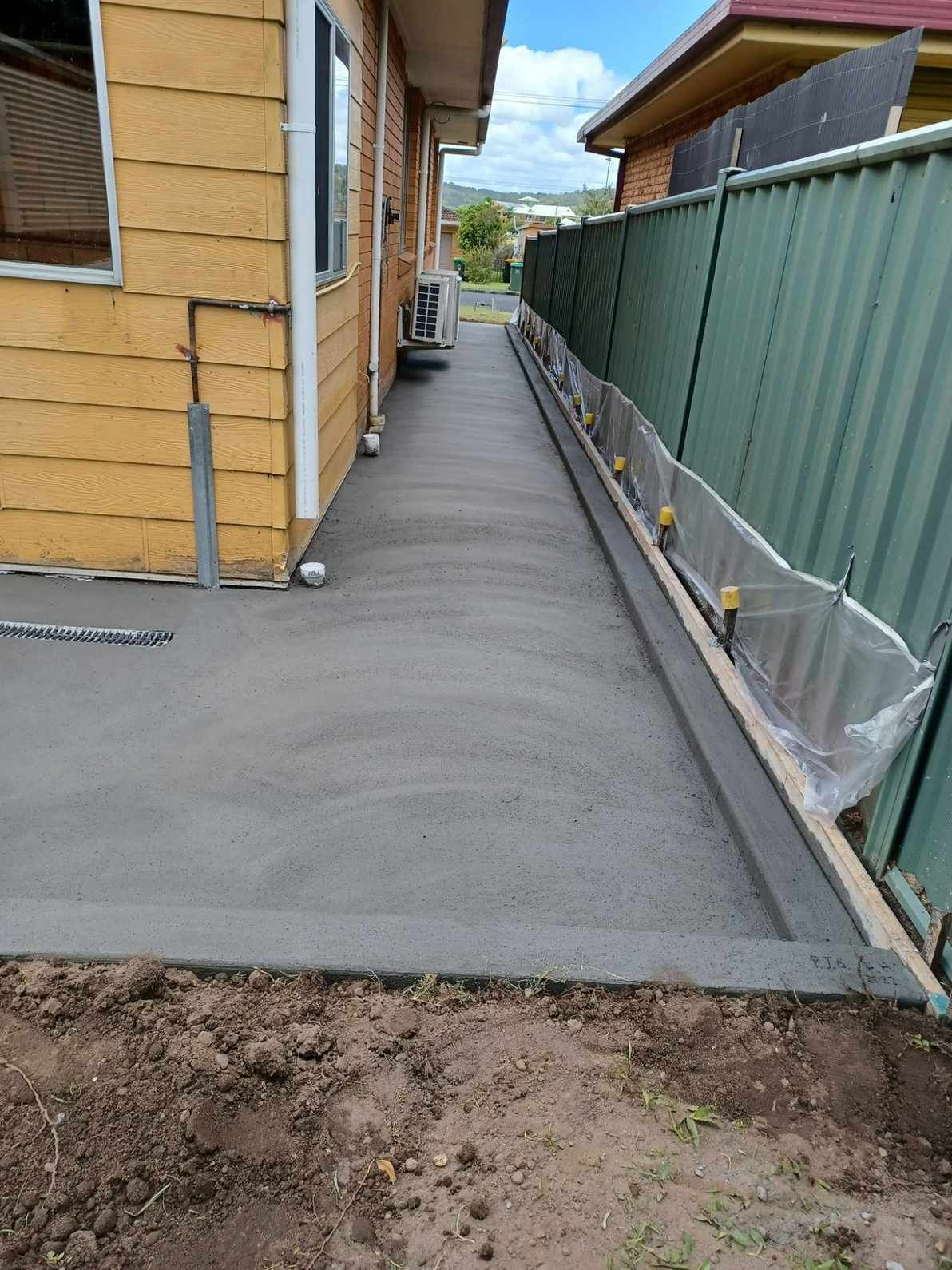 A Concrete Walkway is Being Built in Front of a House — Brocksolid Concrete in Pillar Valley, NSW