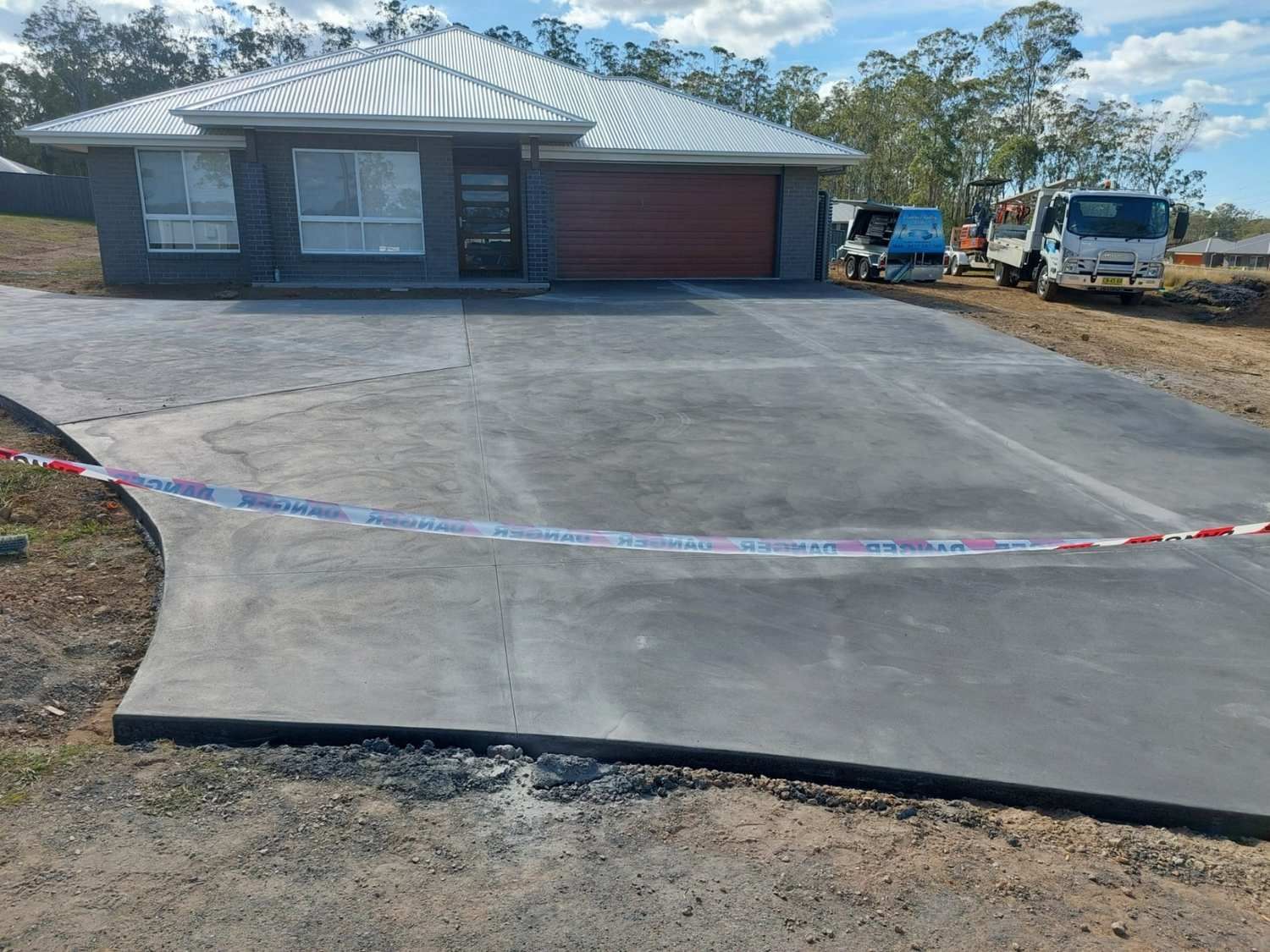 A Concrete Driveway is Being Built in Front of a House — Brocksolid Concrete in Pillar Valley, NSW