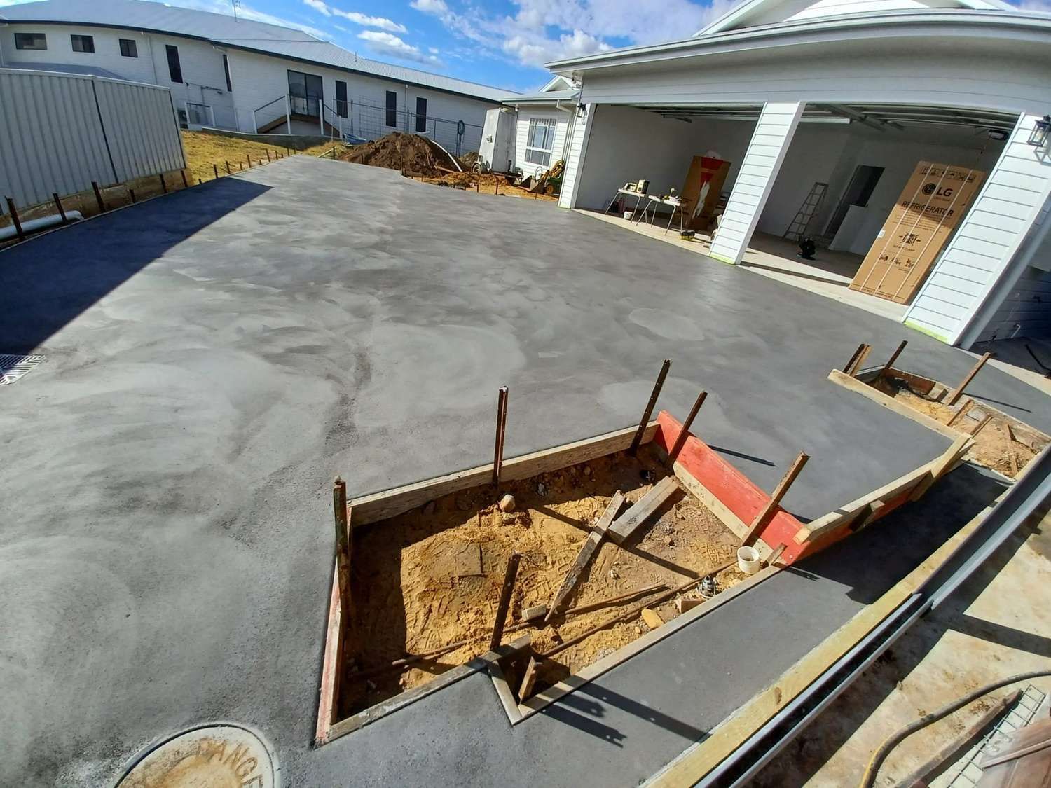 A Concrete Driveway is Being Built in Front of a House — Brocksolid Concrete in Pillar Valley, NSW