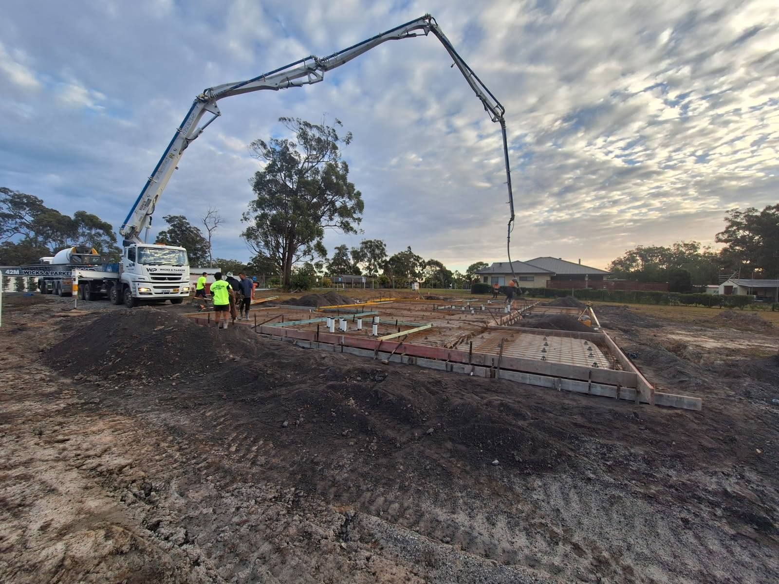 Concrete pump truck pouring house foundation slab at construction site. — Brocksolid Concrete in Pillar Valley, NSW