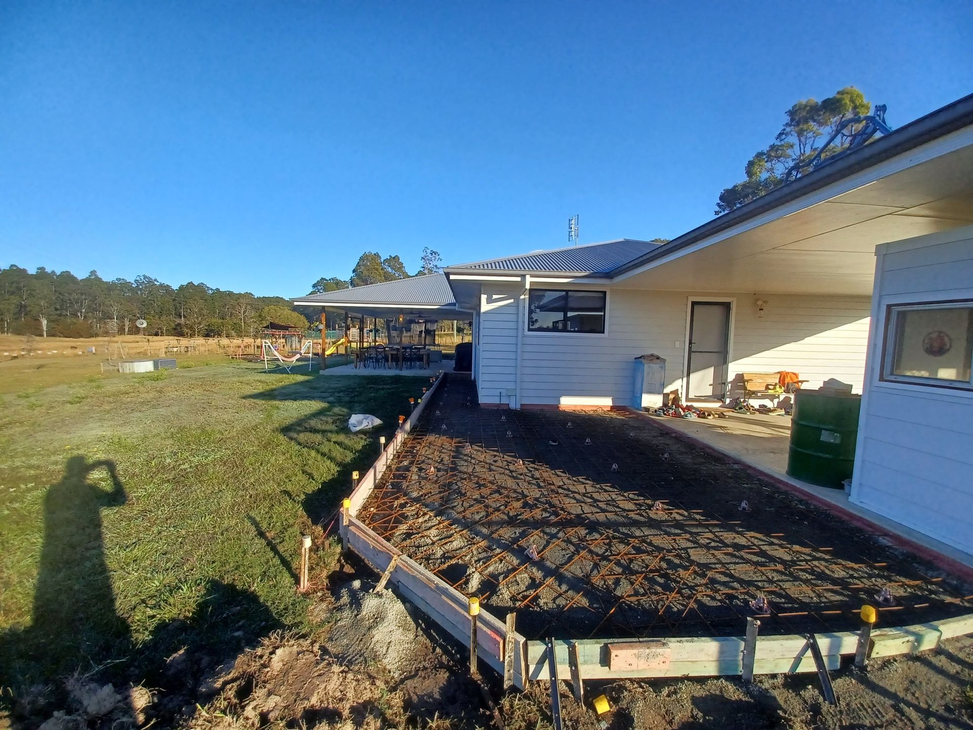 Concrete slab area prepared with reinforcement mesh beside house. — Brocksolid Concrete in Pillar Valley, NSW