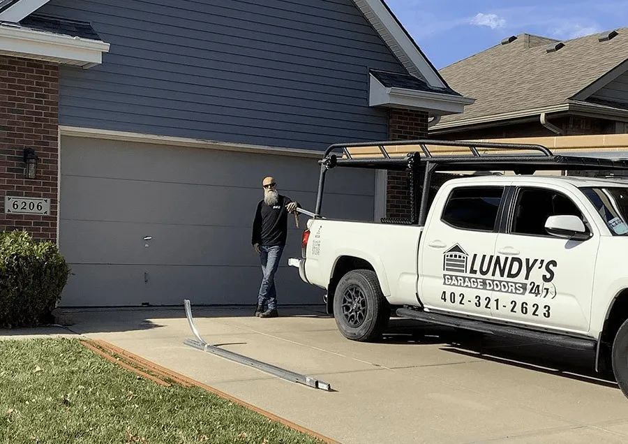 A man is standing next to a truck parked in front of a house.