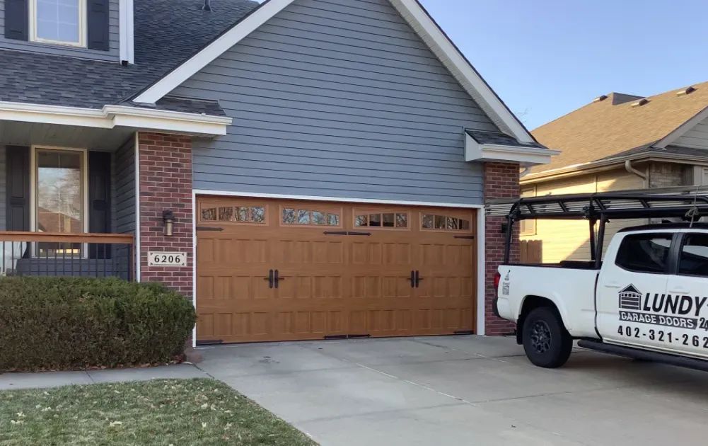 A truck is parked in front of a house with a garage door.