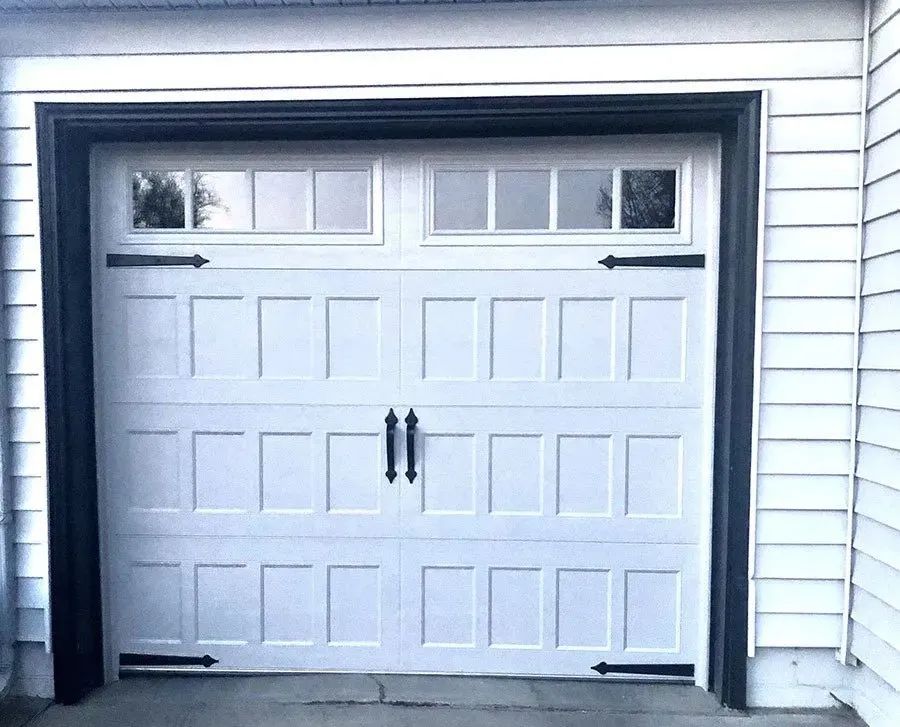 A white garage door with black handles and windows