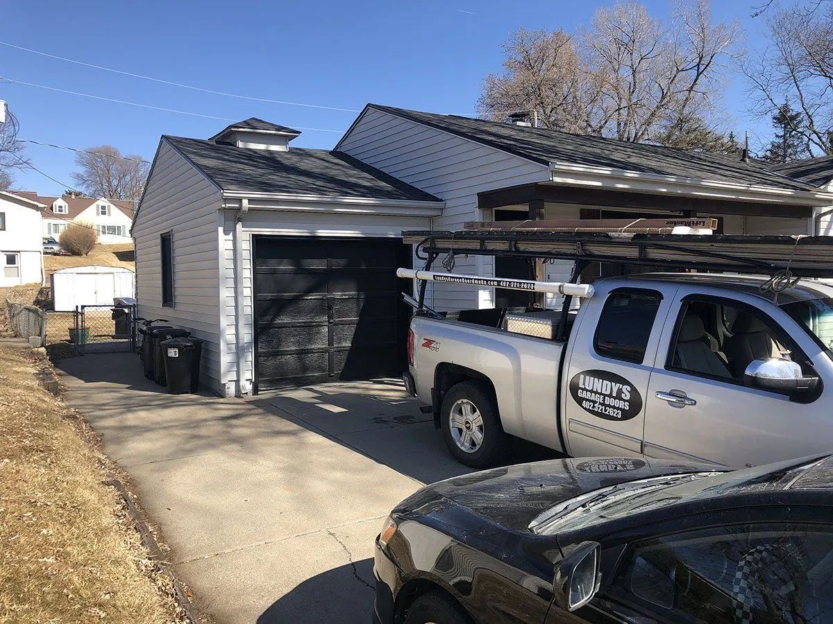 A truck is parked in front of a house in a driveway.