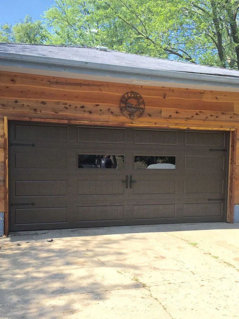 A garage with a wooden roof and a brown garage door.