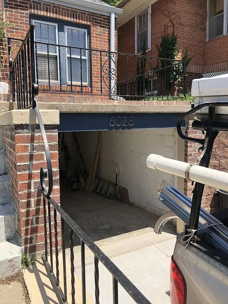 A truck is parked in front of a brick house.