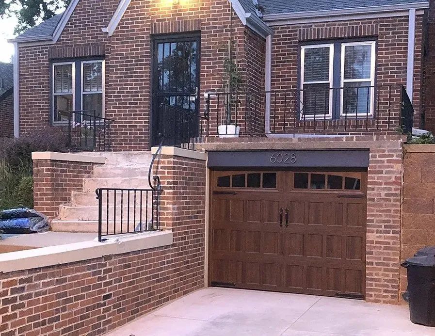 A brick house with a wooden garage door
