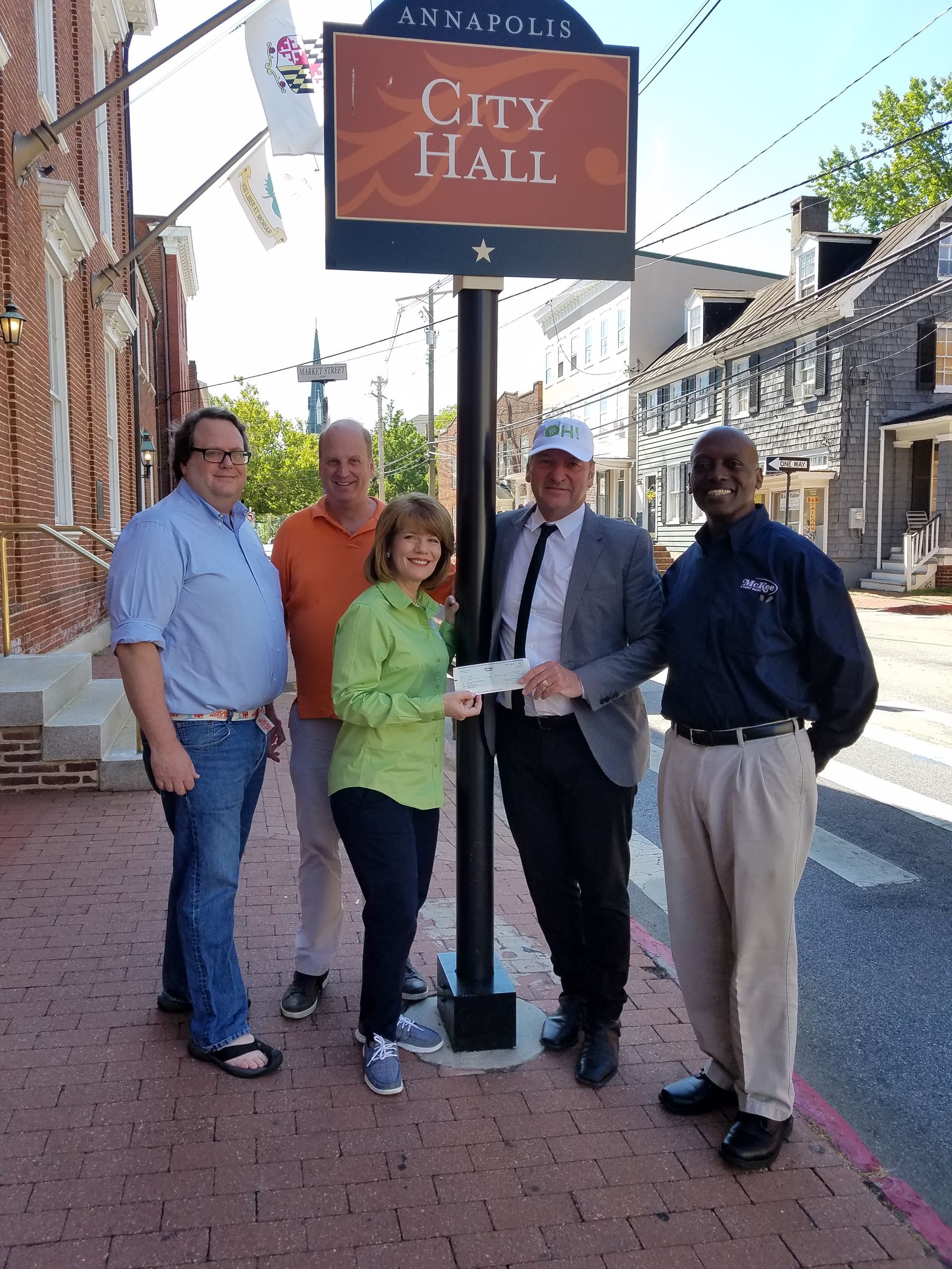 A group of people standing in front of a city hall sign