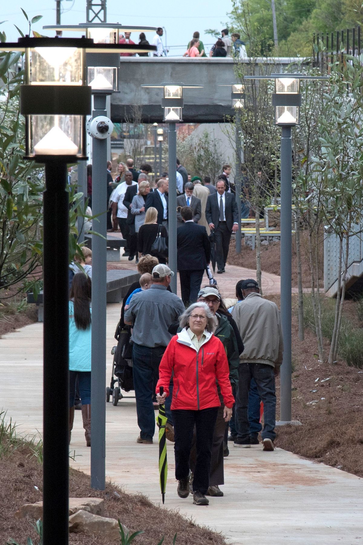 A woman in a red jacket is walking down a sidewalk