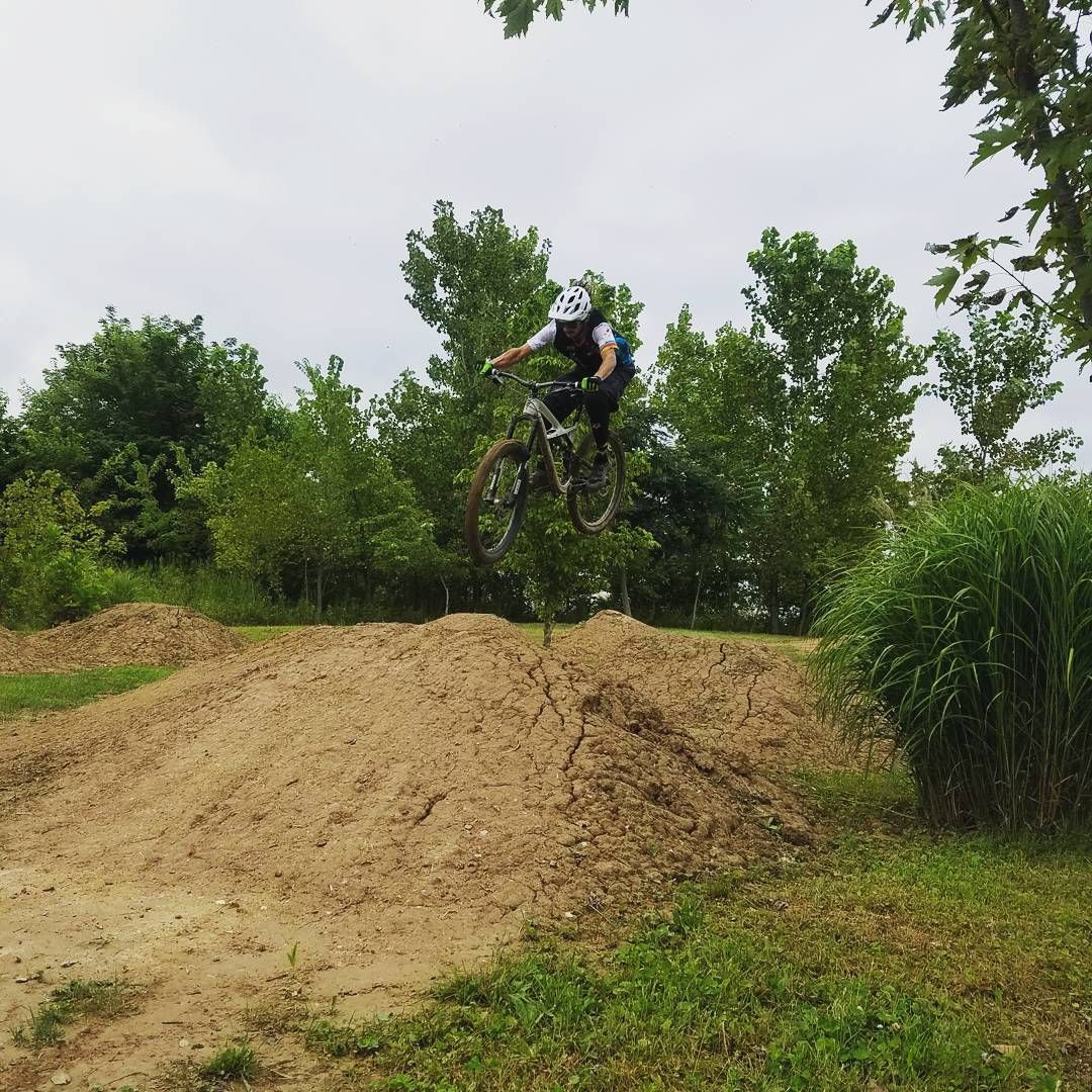 A person on a bike is jumping over a dirt hill.